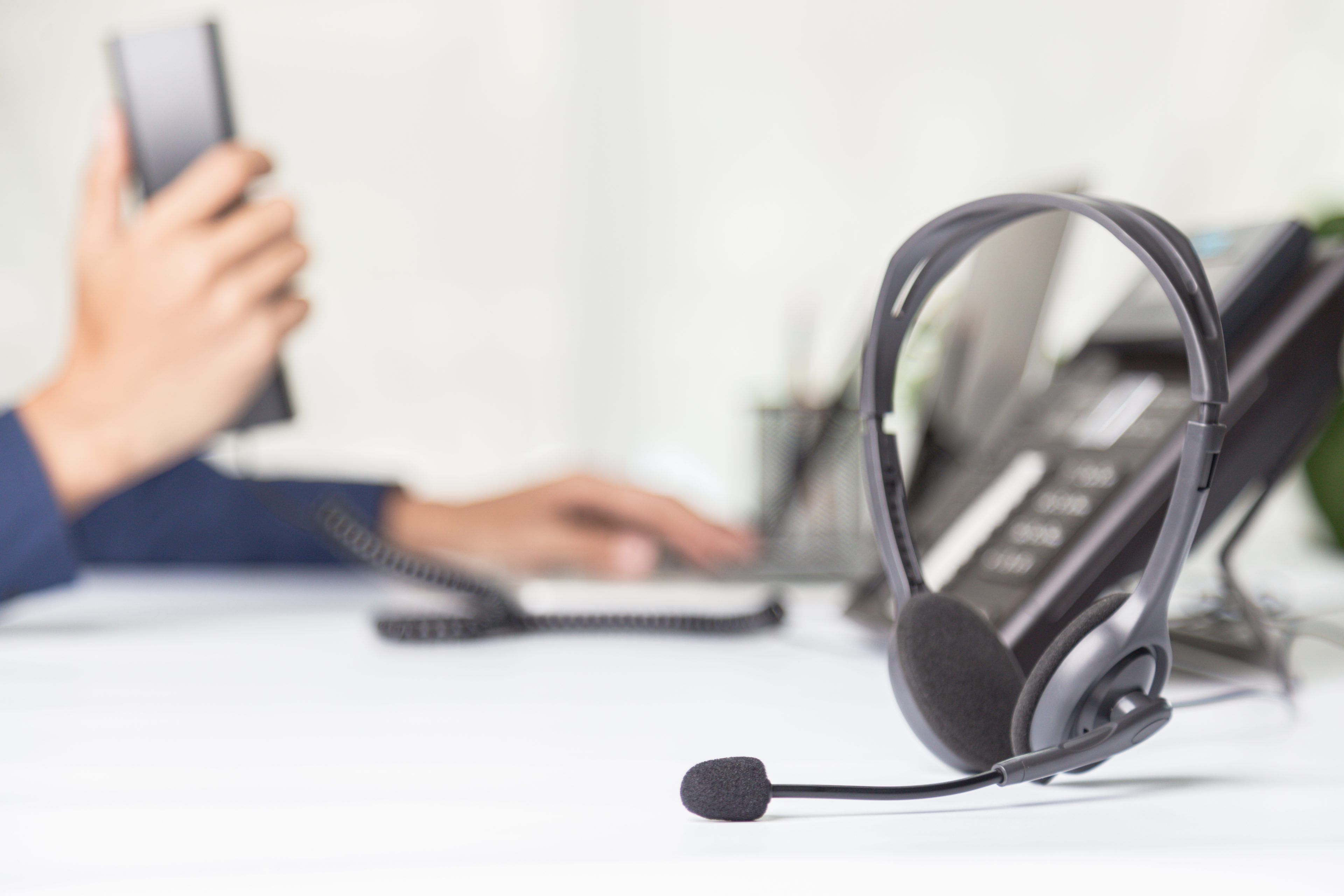 Call center staff man hand point to press the button number on the phone office desk , Communication support, call center and customer service help desk. for (call center) concept